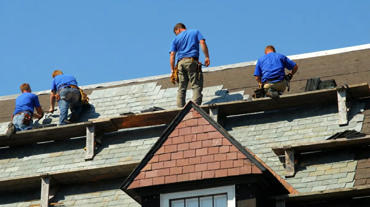 Roof replacement in progress with a team of professional contractors installing new shingles on a residential home in Louisville, KY